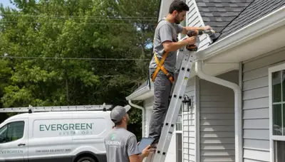 Technician repairing residential gutters on vinyl-sided home in Pittsburgh, PA